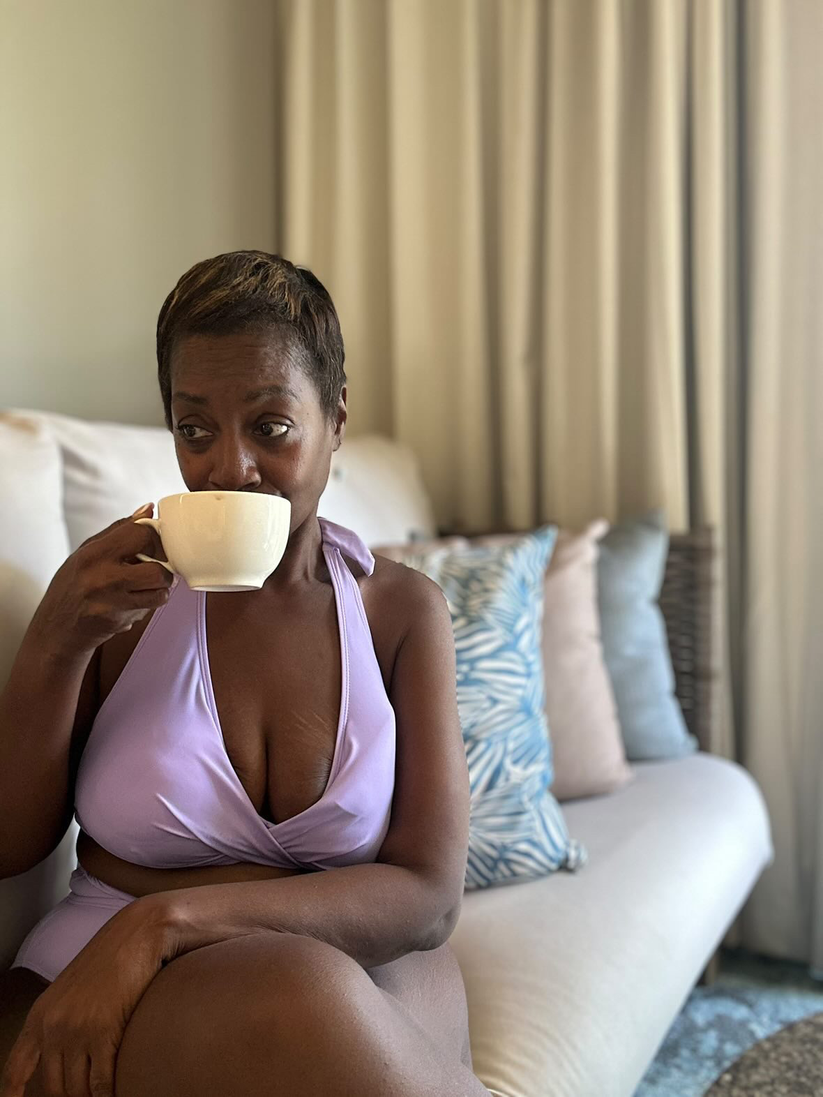 Arliee sipping from a teacup in a quiet morning room